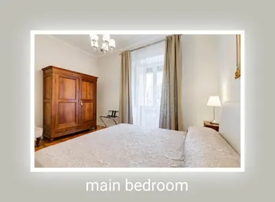 a bedroom with a large bed with a wooden cabinet at Eluta Holiday Home in Rome