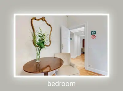 a table and a chair with a vase of flowers on it at Eluta Holiday Home in Rome