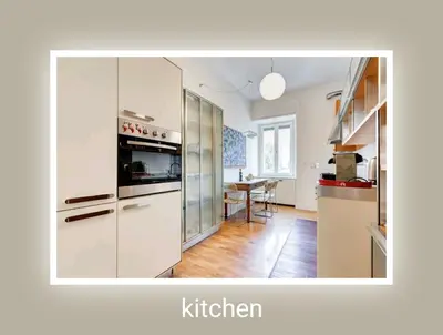 a kitchen with white cabinets and a table in it at Eluta Holiday Home in Rome