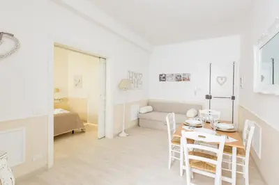 a white living room with a table and chairs at La Maison de la vie in Rome