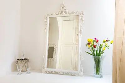 a mirror on a shelf with flowers in a vase at La Maison de la vie in Rome