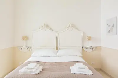 a white bed with two white towels on it at La Maison de la vie in Rome