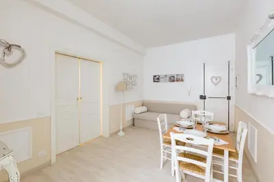 a white living room with a table and chairs at La Maison de la vie in Rome