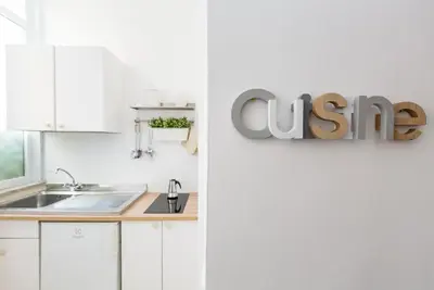 a kitchen with white cabinets and a sign that reads cuisine at La Maison de la vie in Rome