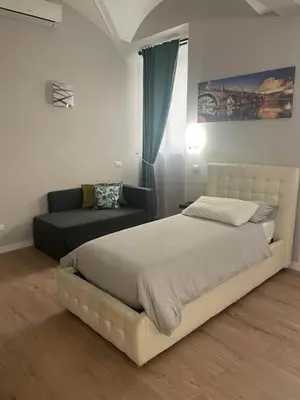 a bedroom with a large bed and a couch at Holiday House Roma Vaticano in Rome