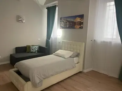 a small bedroom with a bed and a chair at Holiday House Roma Vaticano in Rome