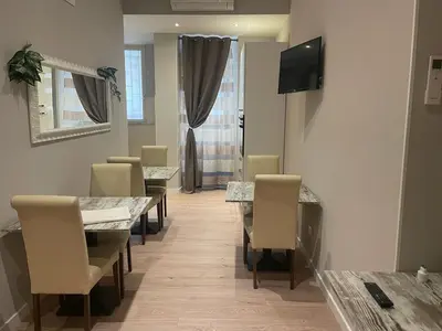 a dining room with tables and chairs and a television at Holiday House Roma Vaticano in Rome