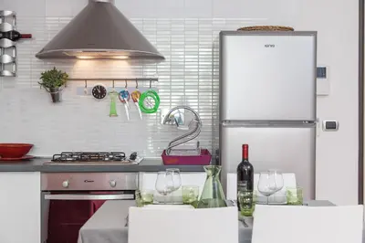 a kitchen with a refrigerator and two wine glasses at Boutique Domus in Rome