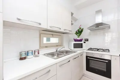 a white kitchen with a sink and a microwave at Boutique Domus in Rome