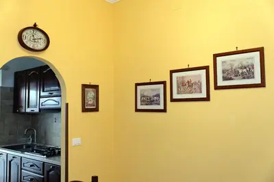 a kitchen with a clock and pictures on the wall at Casa Vacanza Da Andrea in Rome