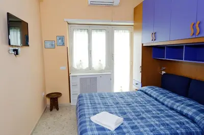 a bedroom with a blue bed and a window at Casa Vacanza Da Andrea in Rome