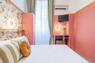 a bedroom with a white bed and a tv at Hotel Espana - Gruppo BLAM HOTELS in Rome