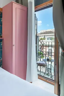 a room with a balcony with a pink cabinet at Hotel Espana - Gruppo BLAM HOTELS in Rome
