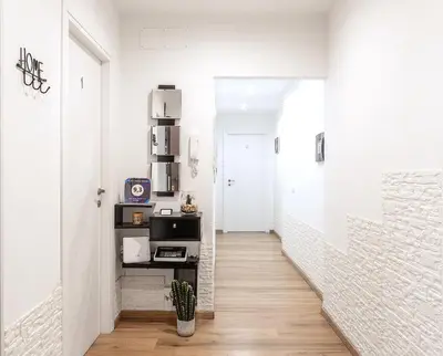 a hallway with white walls and a white staircase at Homs Sweet Home in Rome