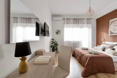 a bedroom with a large bed and a table and a desk at Homs Sweet Home in Rome