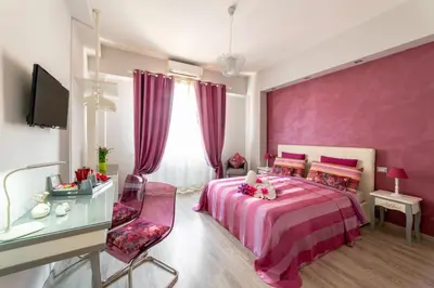 a pink bedroom with a bed and a desk at B&B La Maison de Jo in Rome