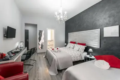 a bedroom with two beds and a living room at B&B La Maison de Jo in Rome