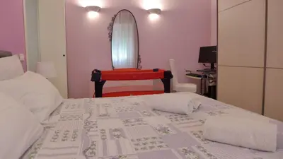 a bedroom with a bed with a chair and a mirror at Your Home at Rome in Rome