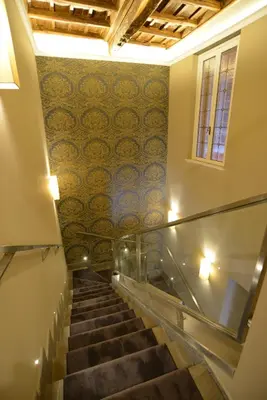 a staircase in a building with a patterned wall at Giuturna Boutique Hotel in Rome