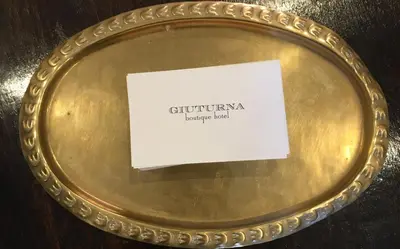 a gold plate with a card on it at Giuturna Boutique Hotel in Rome
