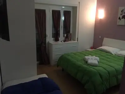 a bedroom with a green bed and a mirror at B&B SPQR in Rome