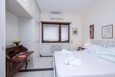a white bedroom with a large bed and a window at Monteverde 2BDR Family Apartment in Rome