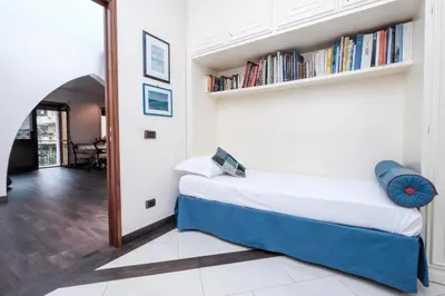 a bedroom with a bed and bookshelves on the wall at Monteverde 2BDR Family Apartment in Rome