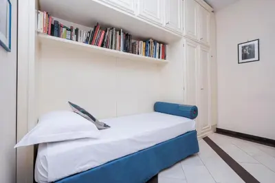 a small bedroom with a bed with bookshelves at Monteverde 2BDR Family Apartment in Rome