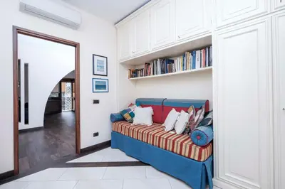 a living room with a blue couch and books at Monteverde 2BDR Family Apartment in Rome