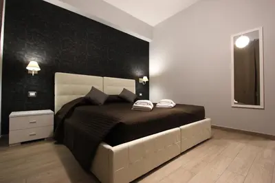 a bedroom with a large bed with a black wall at Pianeta Roma 127 in Rome
