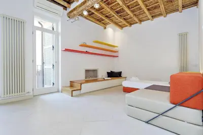 a white room with two beds and a fireplace at Reginella in Rome