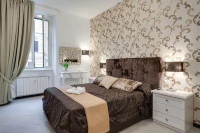 a bedroom with a large bed and a wall with wallpaper at Prime Vatican Suites in Rome