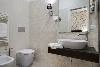 a bathroom with a sink and a toilet and a mirror at Prime Vatican Suites in Rome