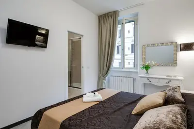 a bedroom with a bed and a tv on the wall at Prime Vatican Suites in Rome