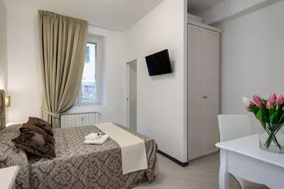 a bedroom with a bed and a table with a vase of flowers at Prime Vatican Suites in Rome