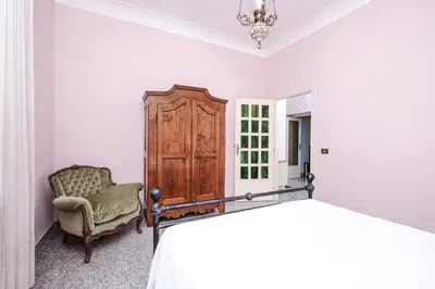 a bedroom with a wooden cabinet and a chair at Villa Pamphili Classic Garden in Rome