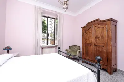 a bedroom with a bed and a wooden cabinet at Villa Pamphili Classic Garden in Rome