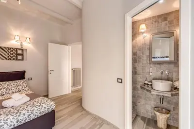 a bedroom with a bed and a bathroom with a sink at Vatican Sweet Home in Rome