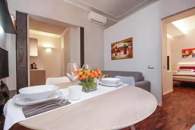 a white table with plates and flowers on it at Living RHome - Condotti Apartment in Rome