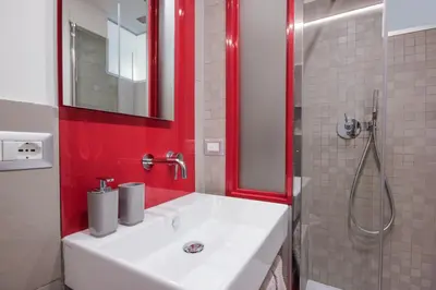 a bathroom with a white sink and a shower at Living RHome - Condotti Apartment in Rome