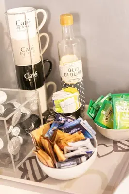 a table with a bowl of chips and a bottle of wine at Living RHome - Condotti Apartment in Rome