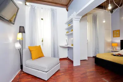 a living room with a chair and a bed at Laterano 238 Apartment in Rome