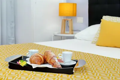 a tray with croissants and coffee cups on a bed at Laterano 238 Apartment in Rome