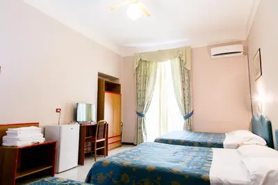 a hotel room with two beds and a window at Hotel Altavilla 9 in Rome
