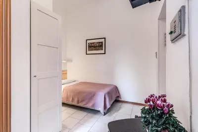 a bedroom with a bed in a white room at Hotel Altavilla 9 in Rome
