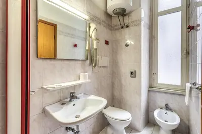 a bathroom with a sink and a toilet and a mirror at Hotel Altavilla 9 in Rome