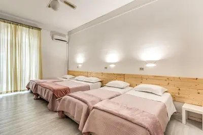 a row of four beds in a room at Hotel Altavilla 9 in Rome