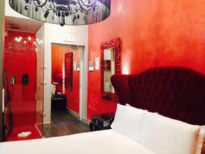 a red bedroom with a bed and a mirror at iRooms Central Station in Rome