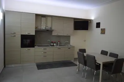 a kitchen with a wooden table and chairs and a table and cabinets at Bea&B in Rome