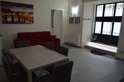 a living room with a table and a red couch at Bea&B in Rome